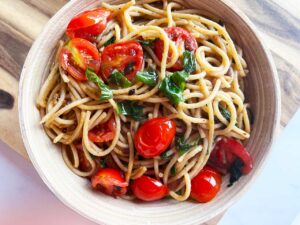 Overhead view of a bowl of Easy Italian Tomato Pasta sitting on a cutting board.