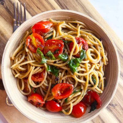Overhead focus. A bowl filled with Easy Italian Tomato Pasta. A fork lays next to the bowl.