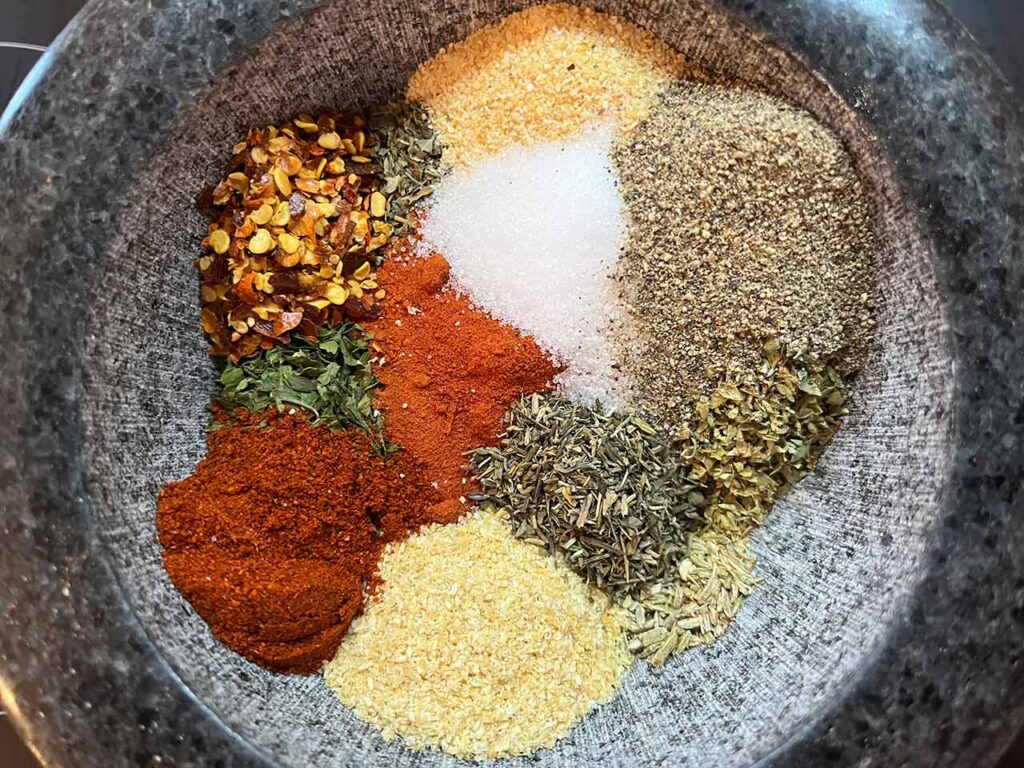 The individual spices for this Copycat Trader Joe's Pizza Seasoning, in a bowl in separate piles.