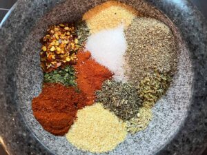 The individual spices for this Copycat Trader Joe's Pizza Seasoning, in a bowl in separate piles.