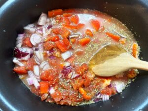 Stirring together all the ingredients in a slow cooker crock.