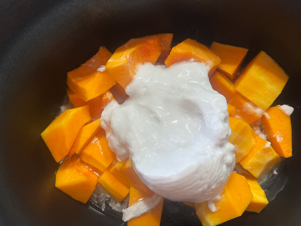 Canned, full-fat coconut milk added to squash in a slow cooker crock.