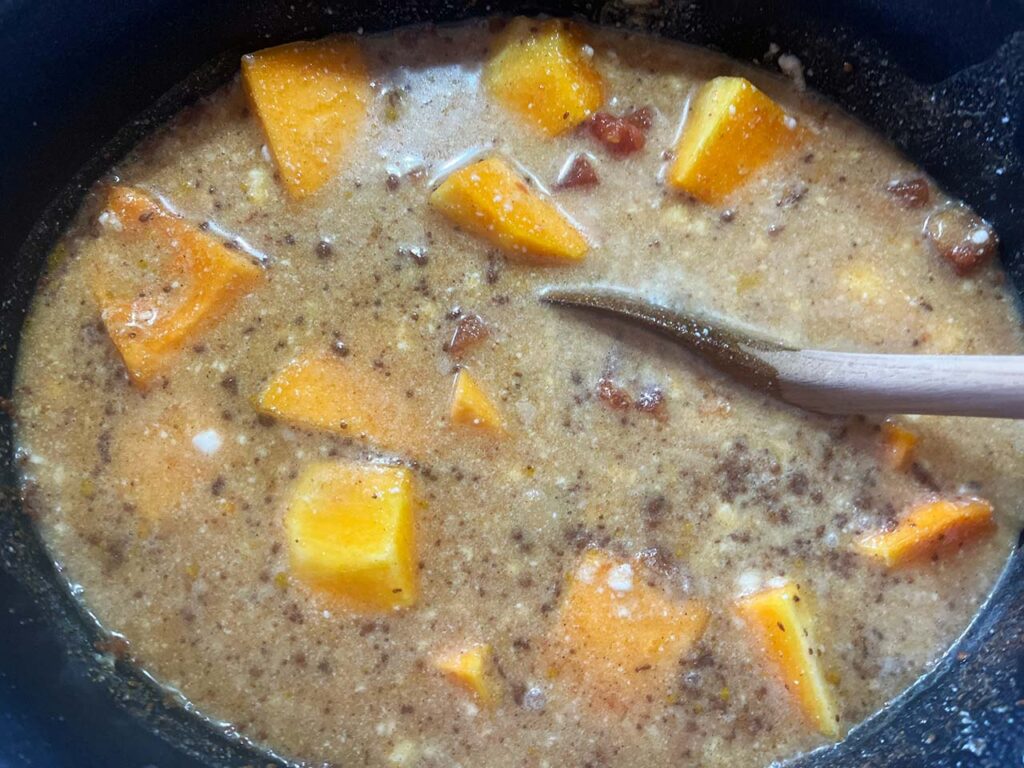 Stirring the ingredients for Slow Cooker Butternut Curry Soup together in a slow cooker crock.