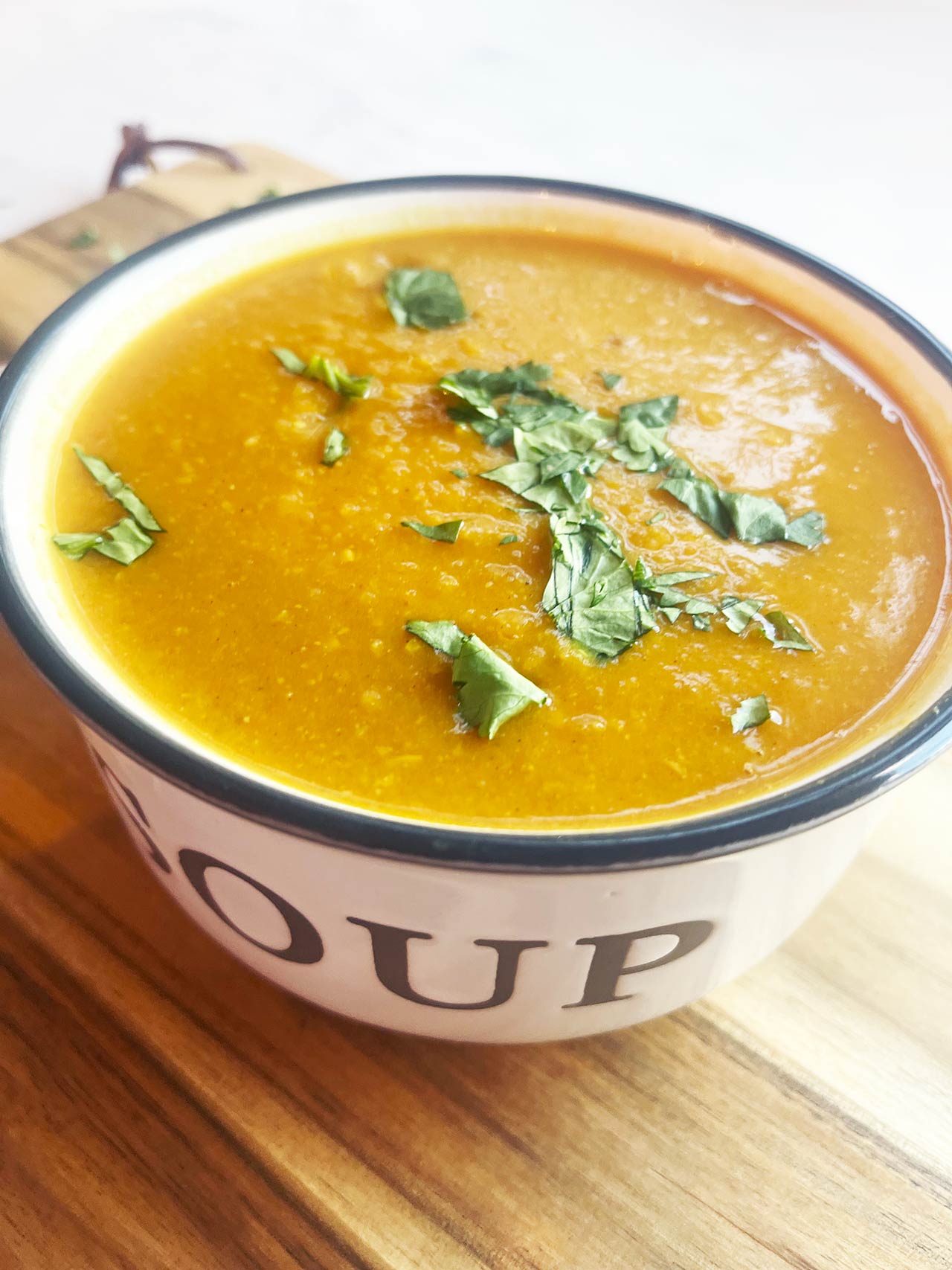 Front view of a bowl of Slow Cooker Butternut Curry Soup in a white soup bowl.