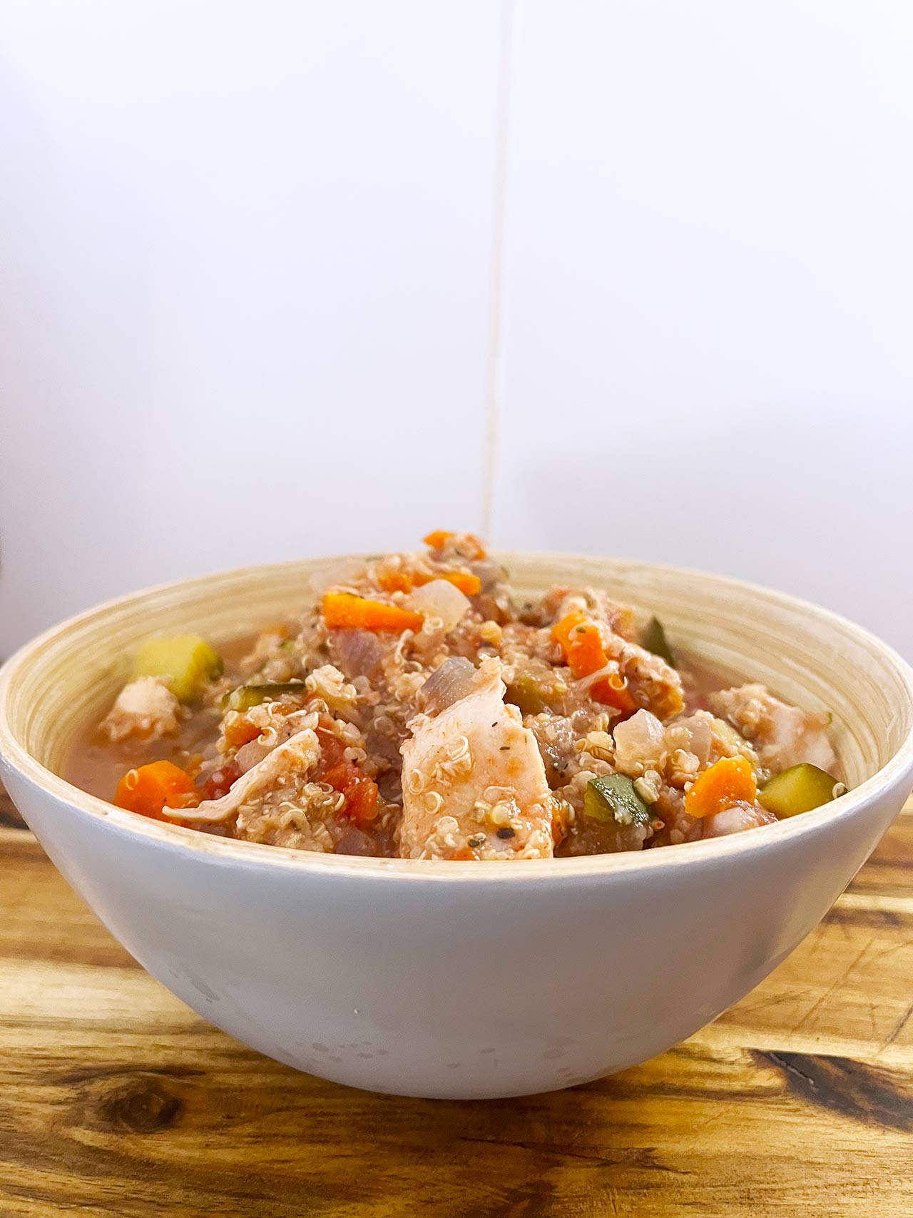 Front direct focus. A bowl filled with Slow Cooker Chicken And Quinoa Stew.