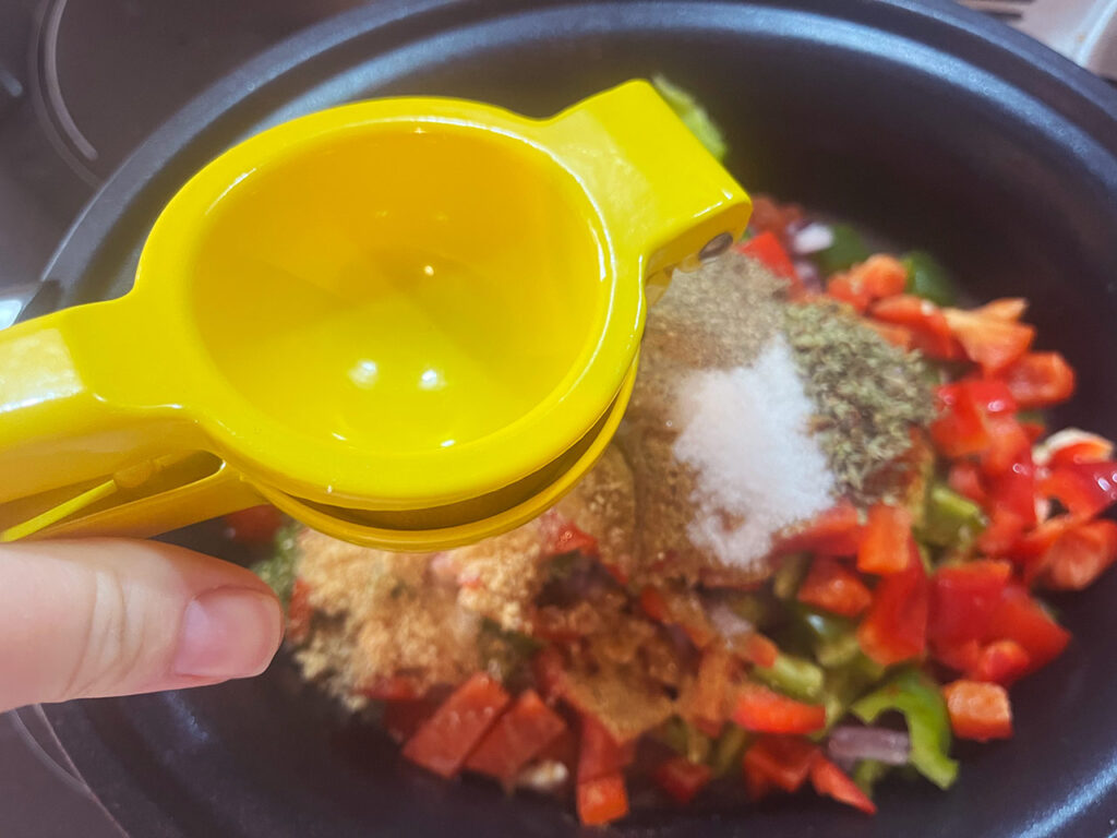 Squeezing fresh lemon juice into a crock full of ingredients for making Slow Cooker Chicken Taco Stew.