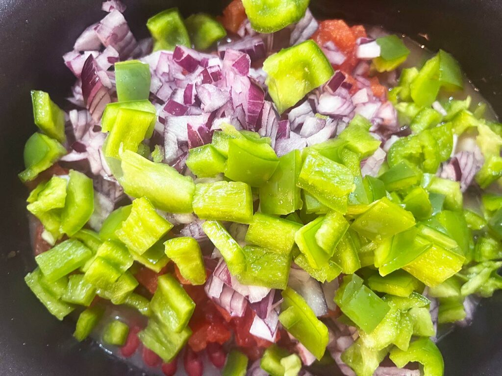 Green bell peppers added to a slow cooker crock.