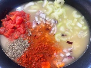 Slow Cooker Shrimp And White Bean Stew Recipe ingredients in a slow cooker crock. Broth added to veggies.
