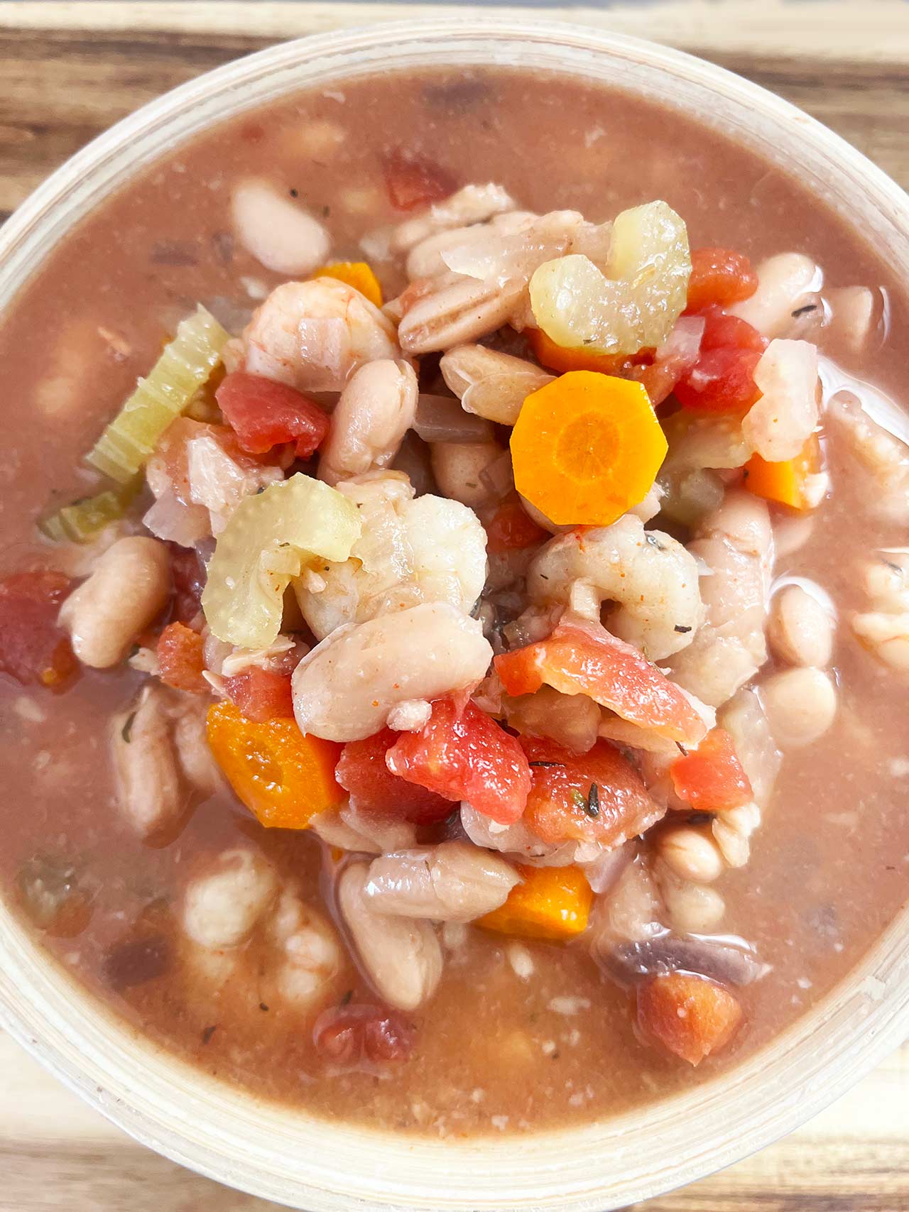 Overhead close up. A full bowl of Slow Cooker Shrimp And White Bean Stew.