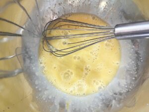 Wet ingredients for apple cookies whisked together in a mixing bowl.
