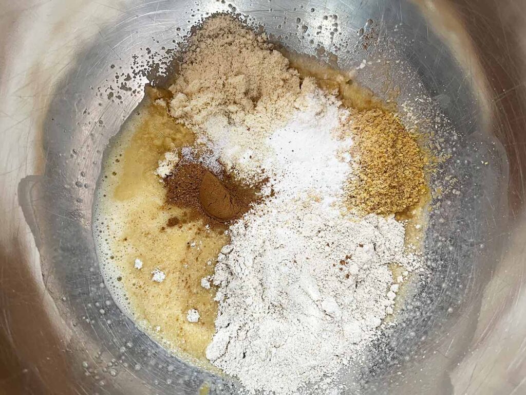 Dry ingredients added to wet ingredients for apple cookies.