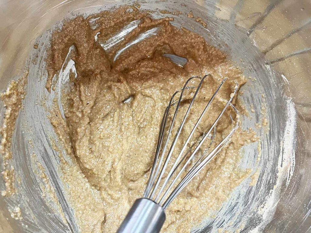 Apple cookie batter whisked together in a mixing bowl.