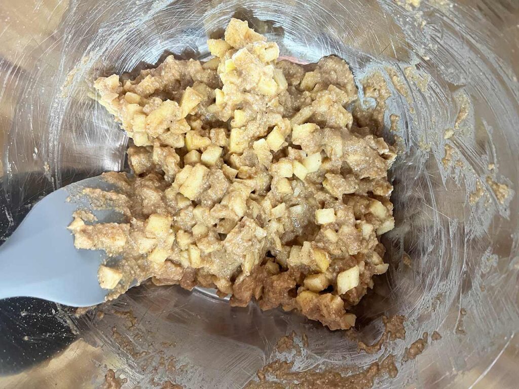 The mixed apple cookie batter in a mixing bowl.