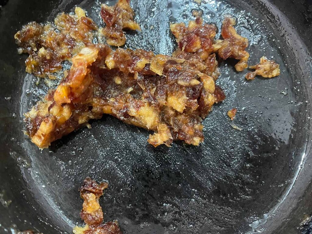 Chopped dates in a skillet have become paste-like.