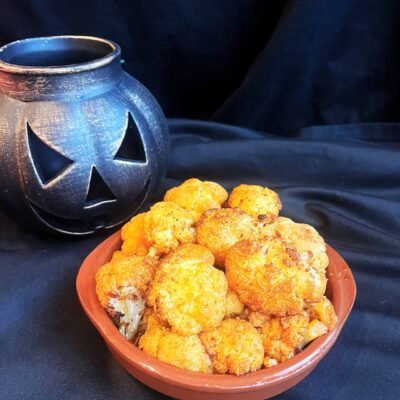 Roasted cauliflower brained served on a small, brown plate.