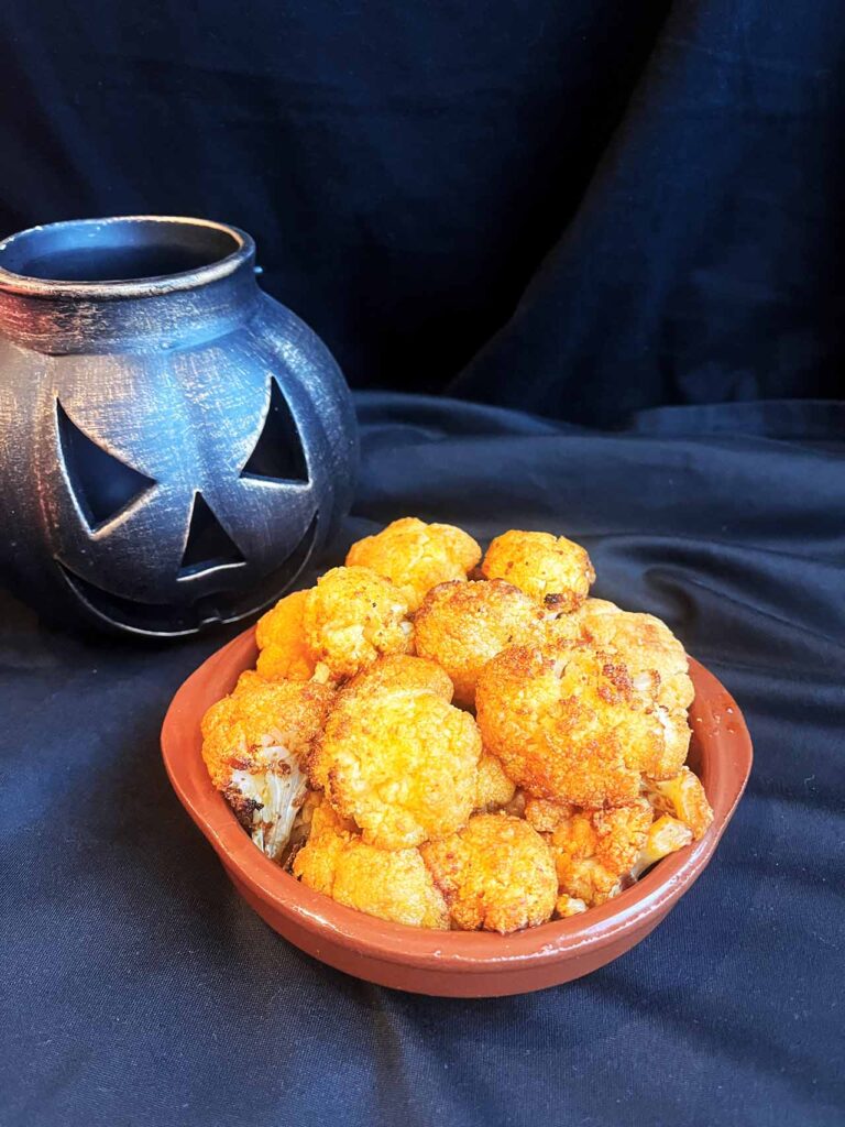Roasted cauliflower brained served on a small, brown plate.
