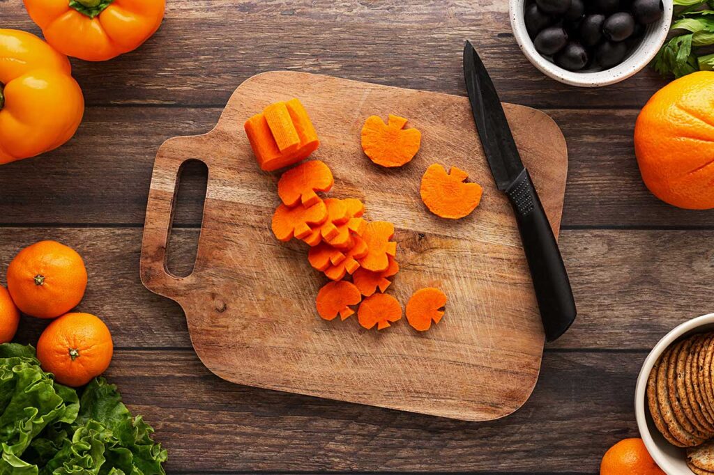 Sliced carrot pumpkins on a cutting board.