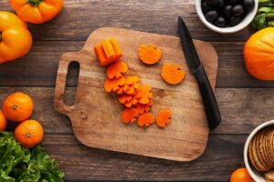Sliced carrot pumpkins on a cutting board.
