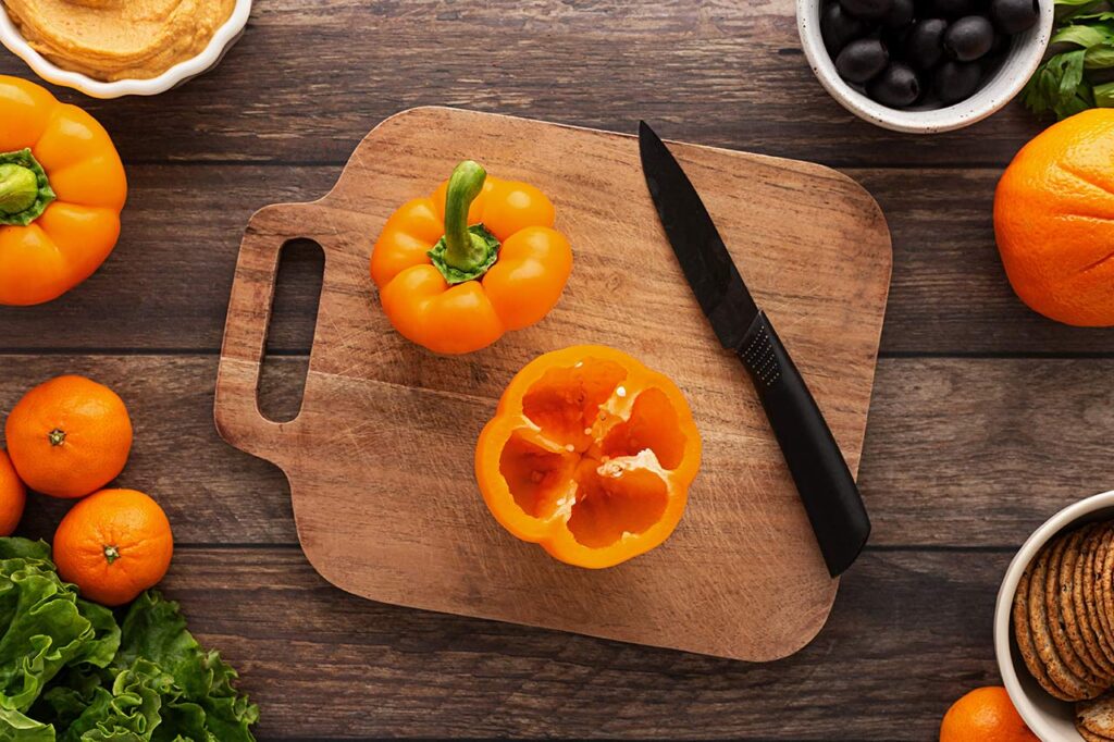 An orange bell pepper with the top cut off. Overhead focus.