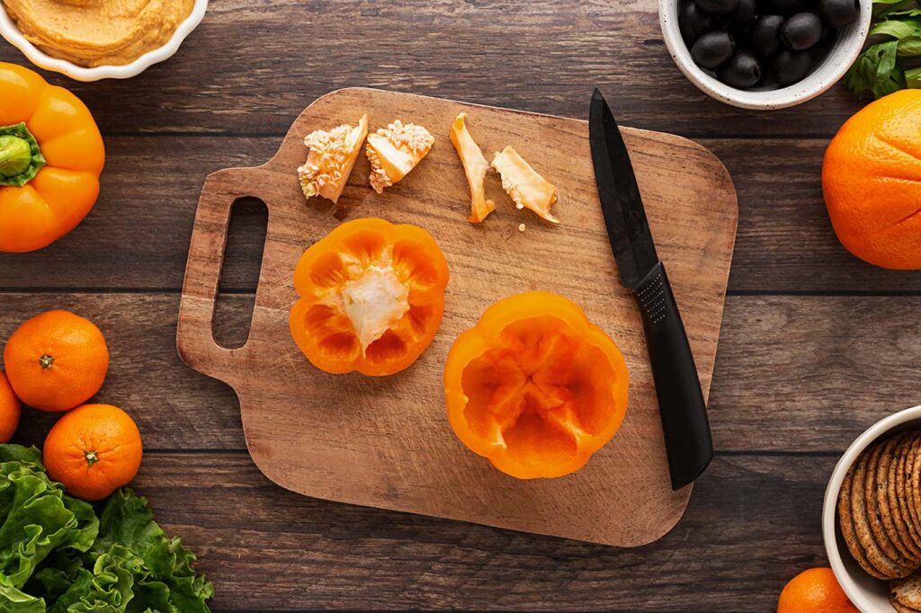 The insides of an orange bell pepper cleaned out to make room in the pepper for dip.