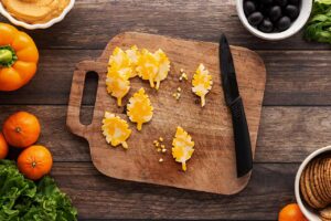 Notches cut into cheese slices to make autumn leaf shapes.