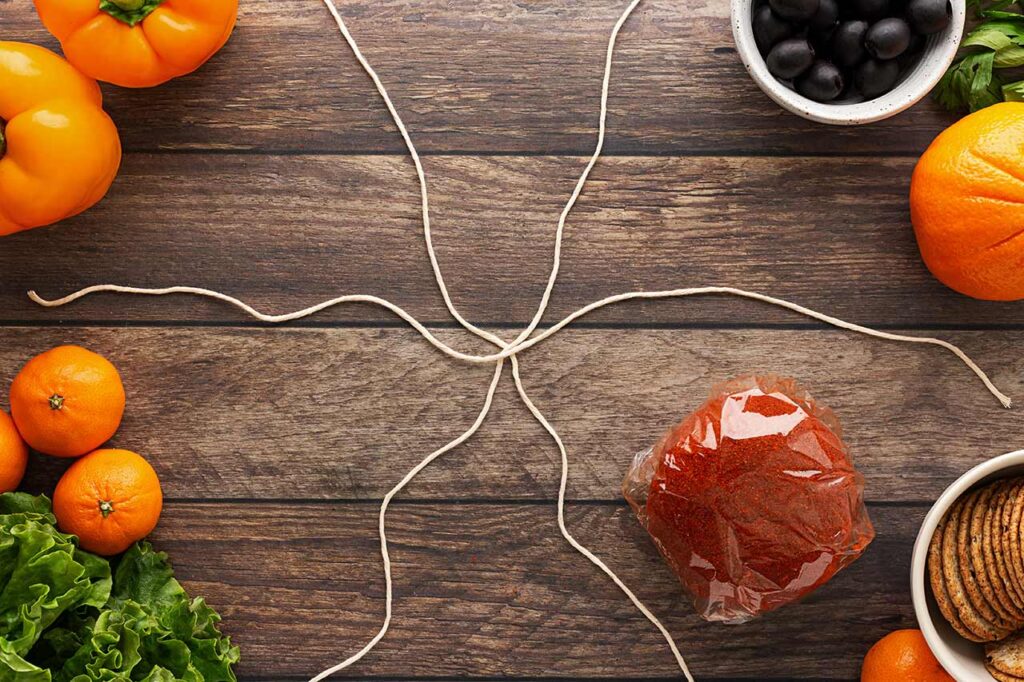 Twine laid out on a wood surface for shaping a pumpkin cheese ball.