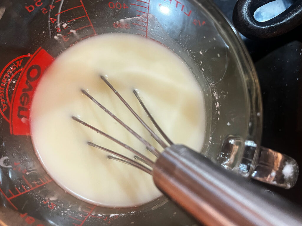 Starch whisked into 1 cup of chicken broth in a measuring cup.