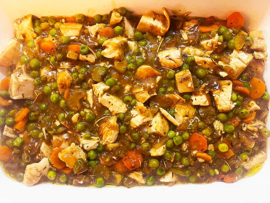Chicken cobbler filling transferred to a casserole dish.