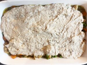 The oat flour topping spread over the filling in a casserole dish.