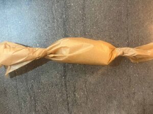 A compound butter log wrapped in parchment paper.