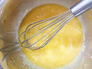 Wet ingredient for Cream Cheese Brownies whisked together in a metal mixing bowl.