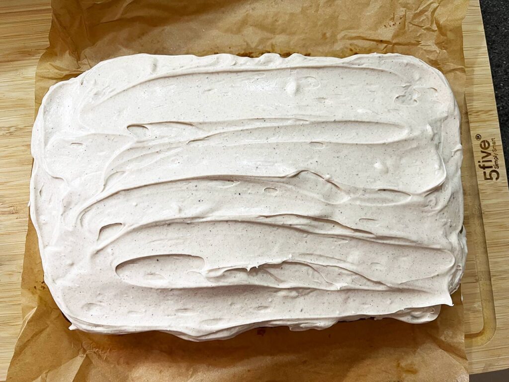 Cream cheese frosting spread over the pumpkin bar loaf.