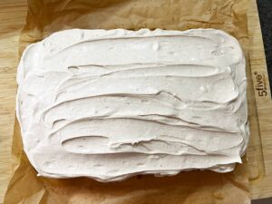 Cream cheese frosting spread over the pumpkin bar loaf.
