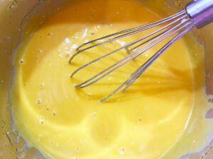 Wet pumpkin bar ingredients whisked together in a mixing bowl.