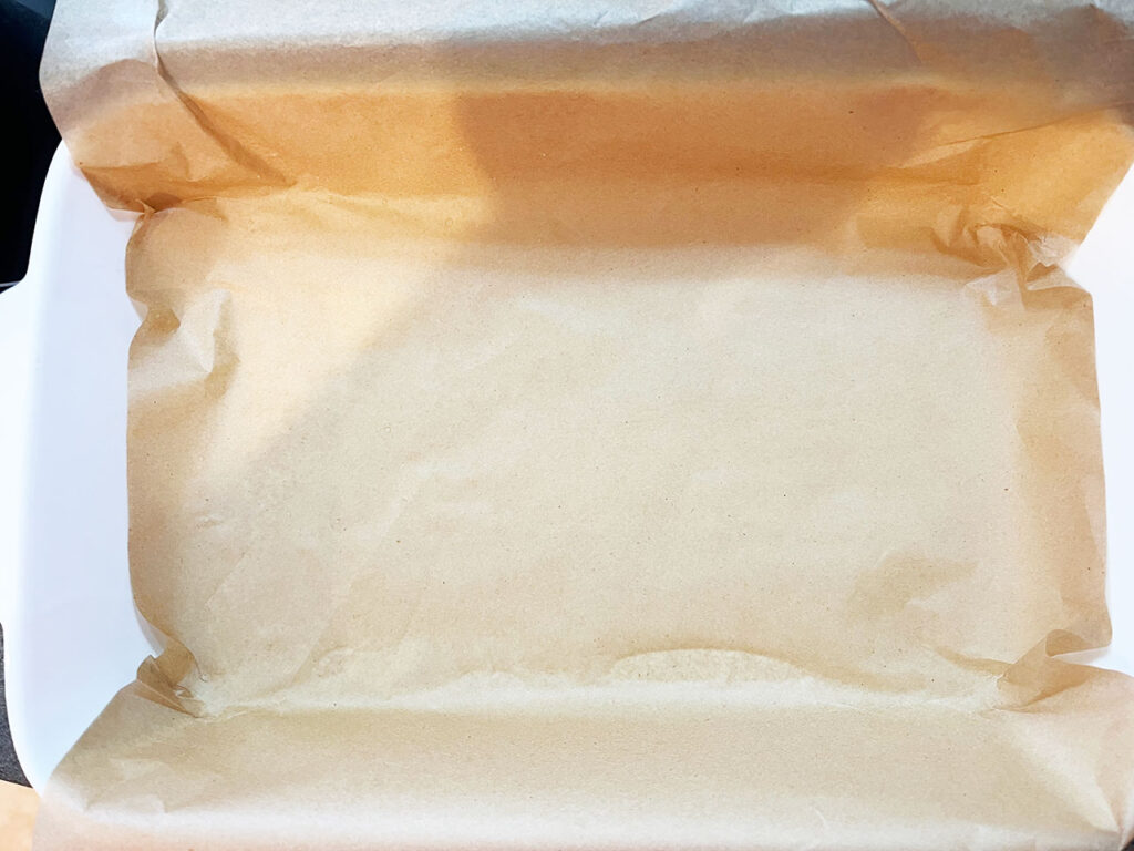 A baking dish lined with parchment paper.