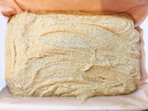 Pumpkin bar batter poured into a parchment-lined baking dish.