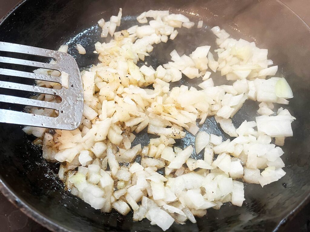 Raw, chopped onions in a skillet.