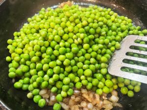 Thawed peas adde to the skillet with onions and garlic.