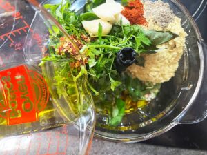 Adding all pistachio pesto ingredients to a food processor.