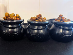 Three mini cauldrons filled with Poisoned Brew Bubbles sitting on a black surface.