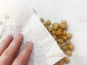 Drying off chickpeas with paper towels.