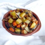 Front view of a brown bowl filled with sheet pan roasted vegetables.