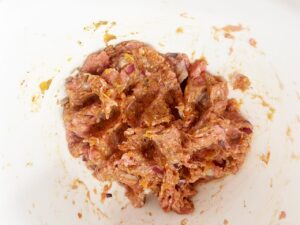 Smokey Pumpkin Turkey Meatballs ingredients mixed together in a white mixing bowl. Overhead focus.
