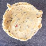 Overhead focus. A white ramekin filled with cowboy butter.