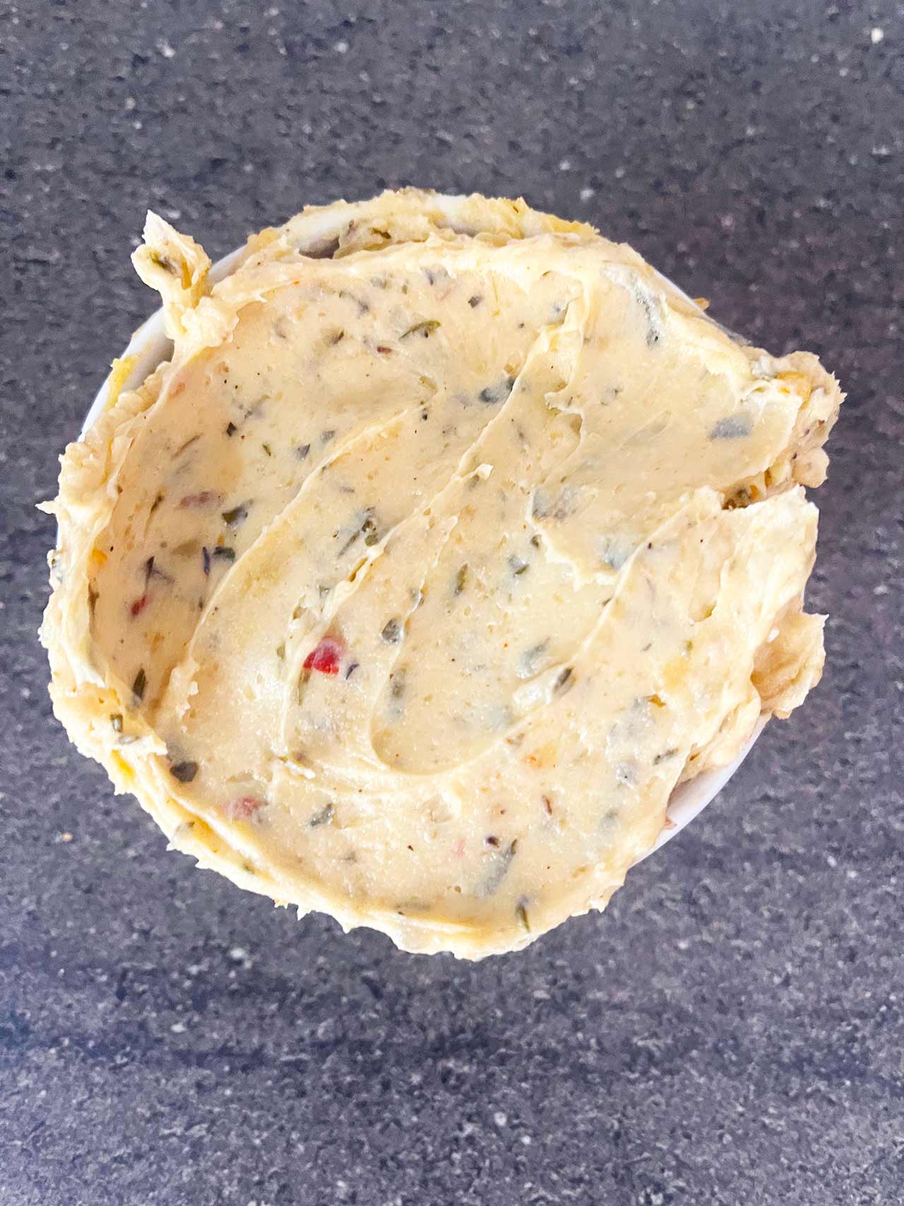 Overhead focus. A white ramekin filled with cowboy butter.
