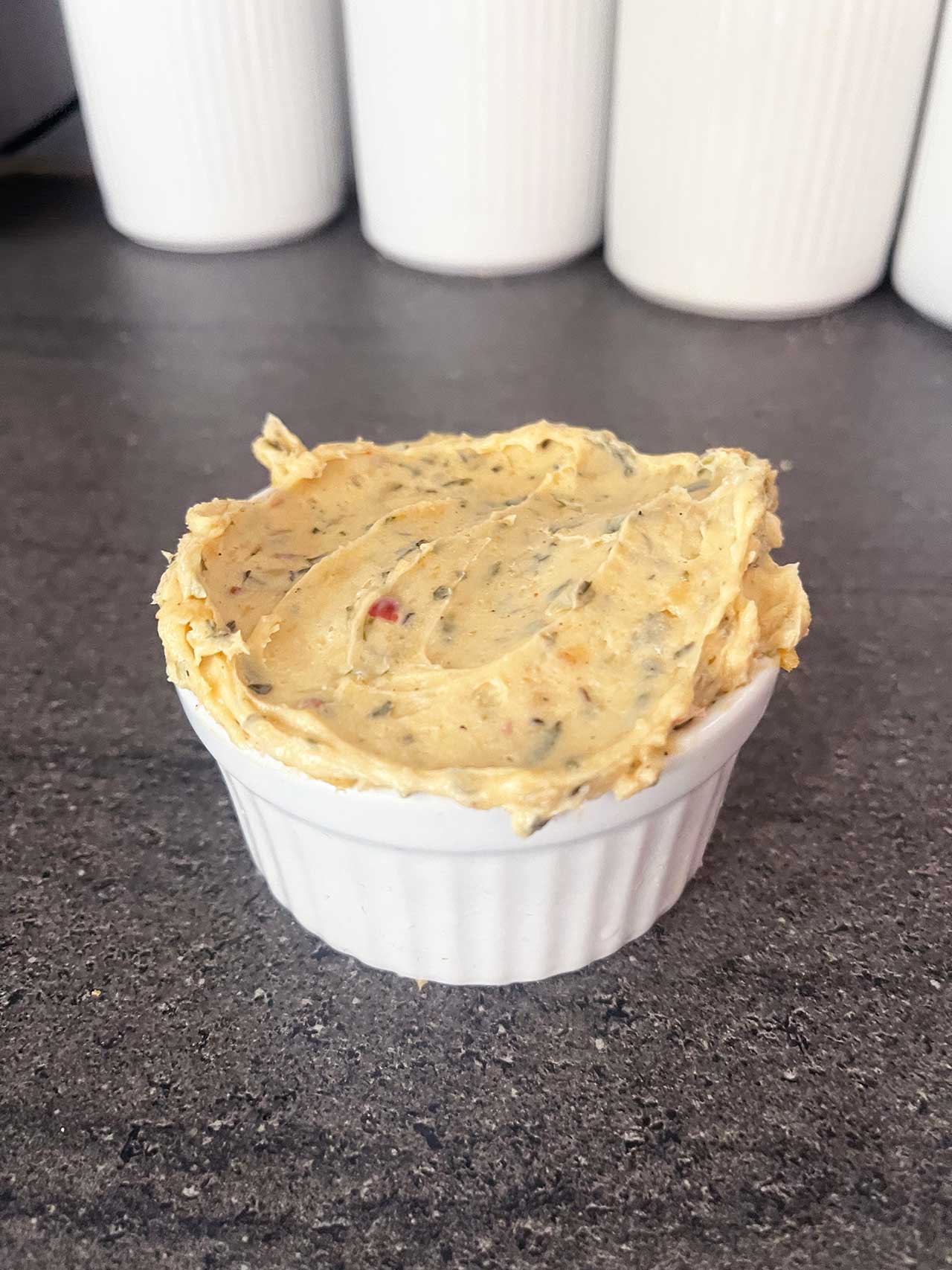 Front focus of a white ramekin filled with cowboy butter.
