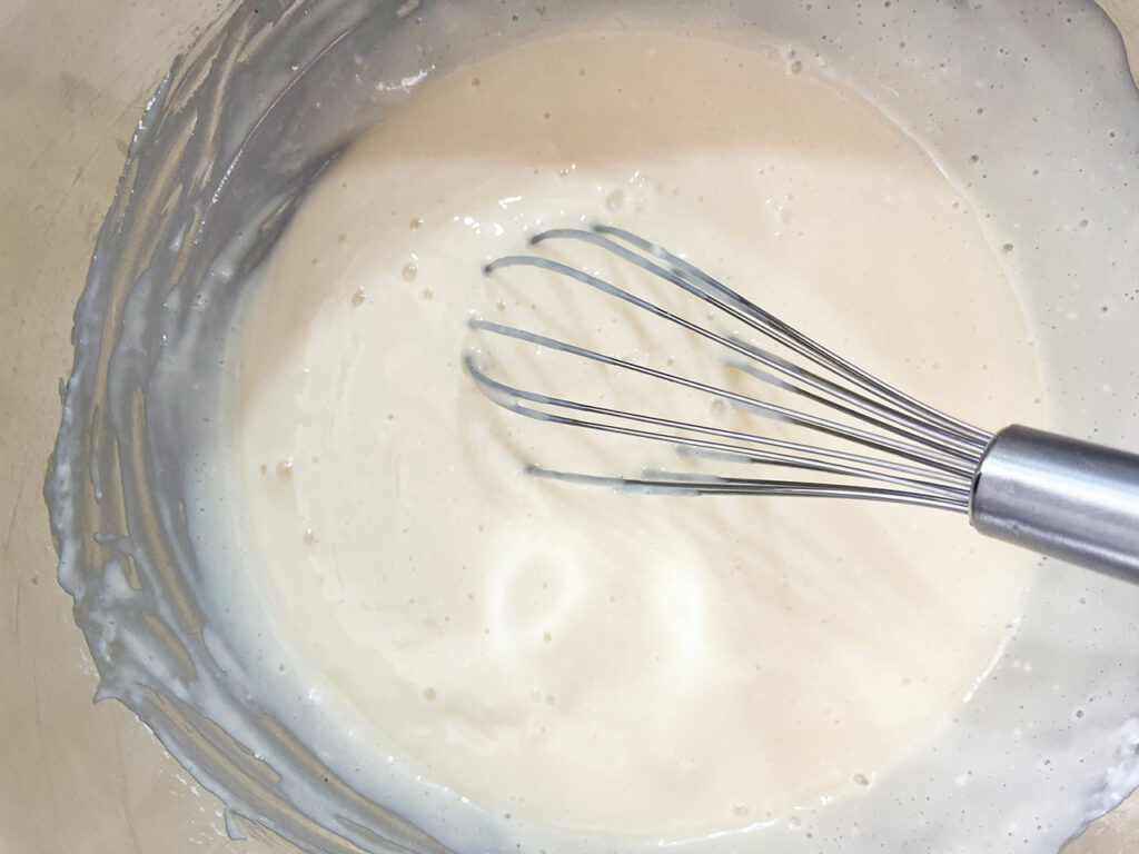 Ingredients for custard pie filling whisked together in a mixing bowl.