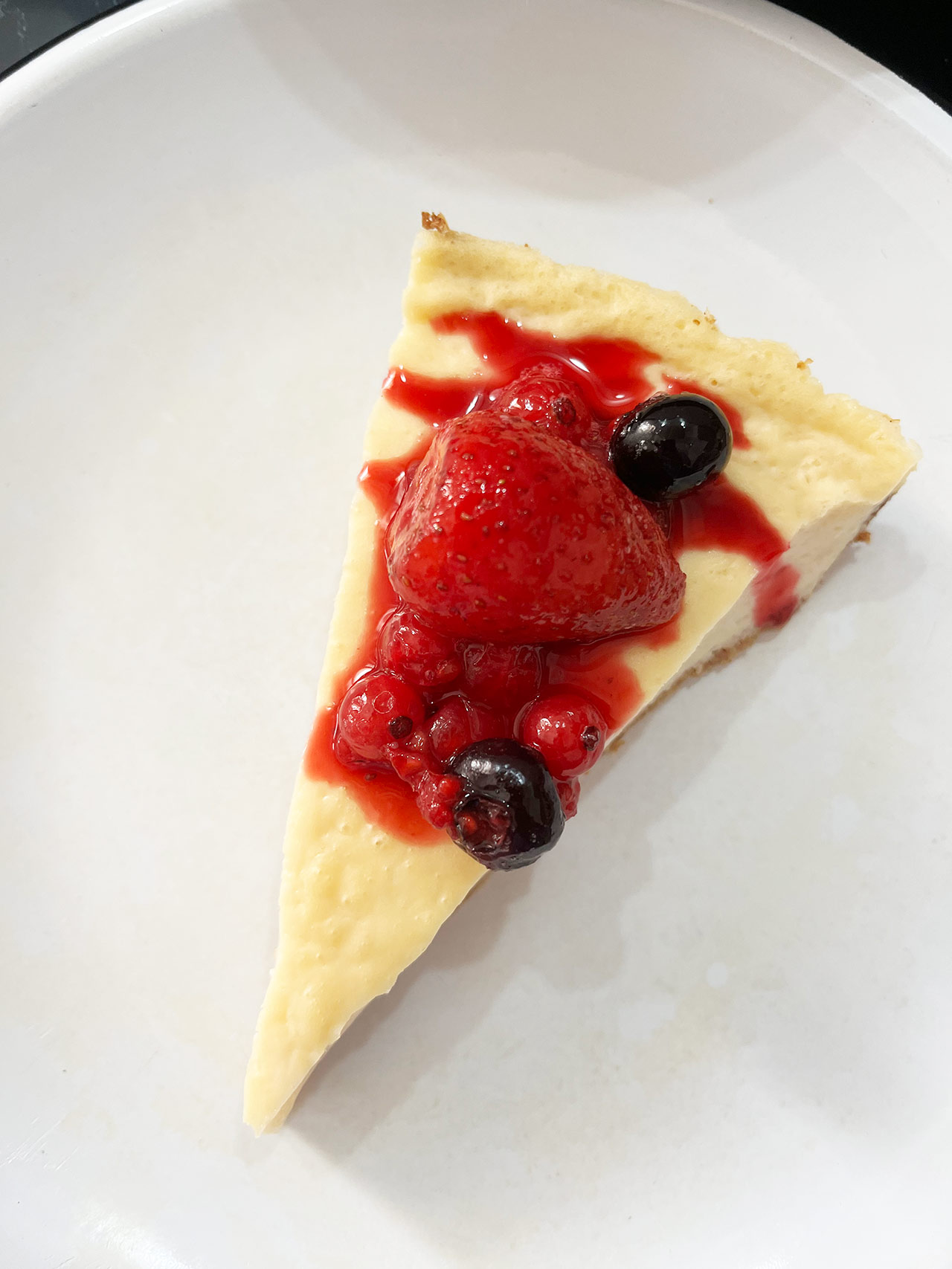 Overhead focus. Berries on a slice of Custard Pie.