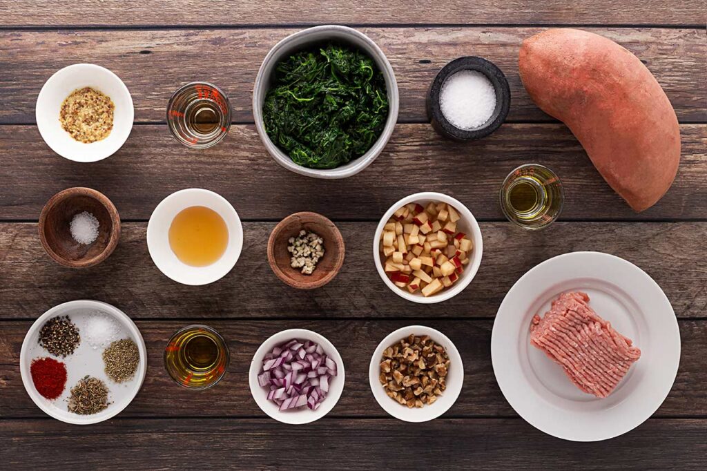 Ingredients for Stuffed Sweet Potato gathered on a wood surface.