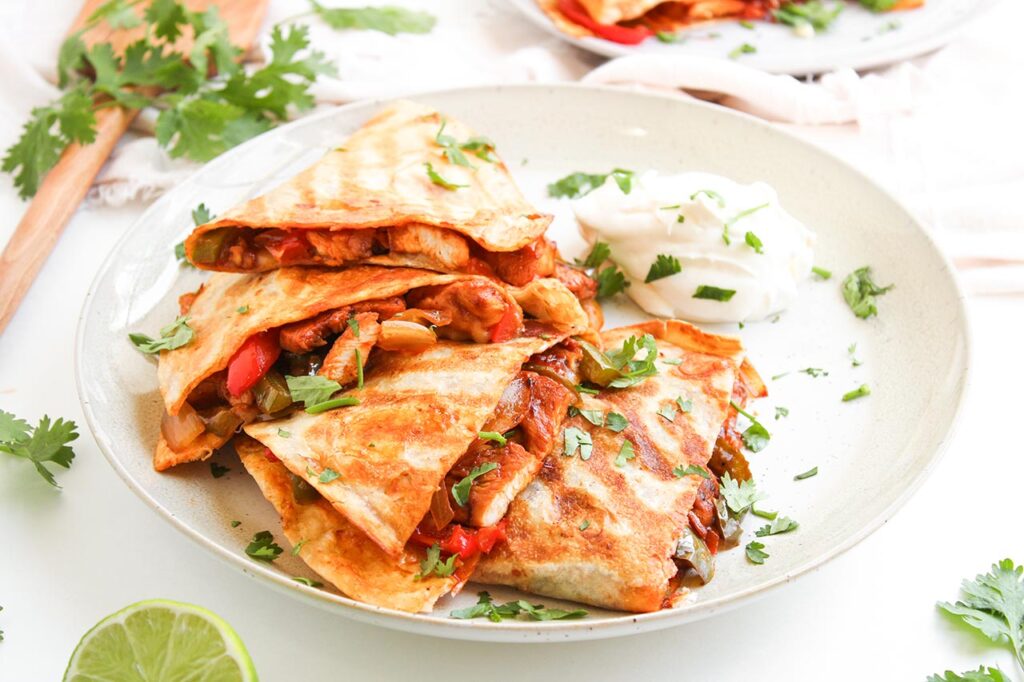 Front focus. Chicken Fajita Quesadillas on a white plate.